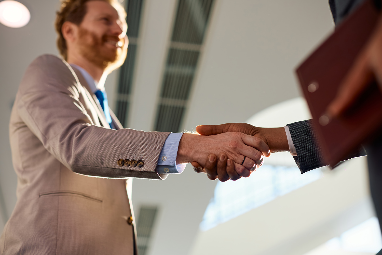 Two businessmen shaking hands, reflecting recruitment by major employers in Utah.