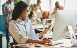 A young employee reviewing paperwork at a computer. Crucial compliance imagery for businesses navigating minor labor laws Utah regulations.