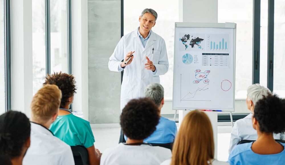 A clinical expert presenting global data to medical professionals. Best practices in recruitment life sciences focus on continuous education.