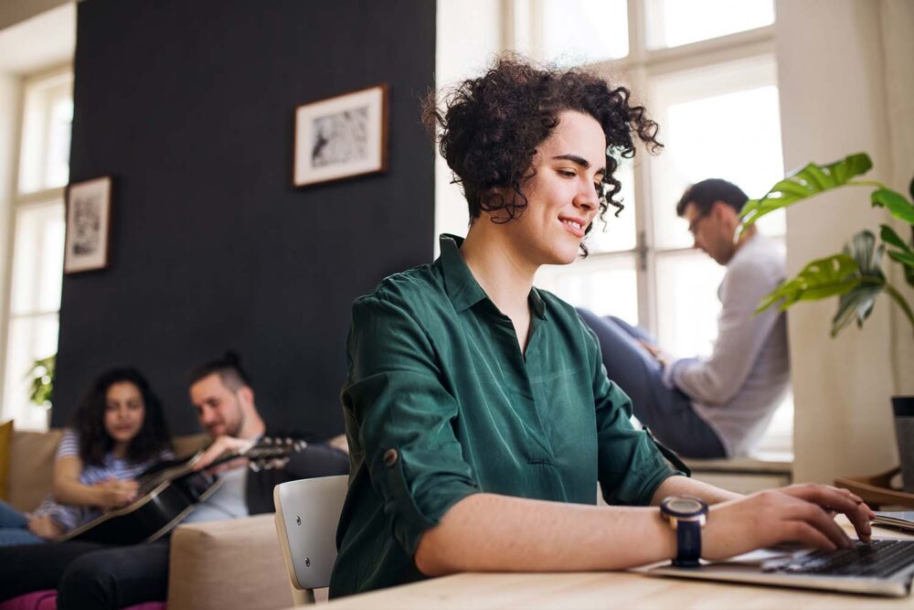 A young adult working on a laptop in a casual setting. Helpful context for employers researching the minimum age to work in utah.