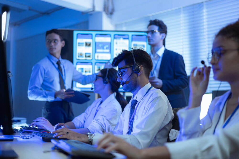 Helpdesk agents with headsets working on computers, a key customer support sector highlighted in ai job displacement statistics.