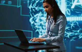 Recruiter wearing a headset and typing on a laptop in front of a glowing AI network graphic, symbolizing AI for recruiters at work