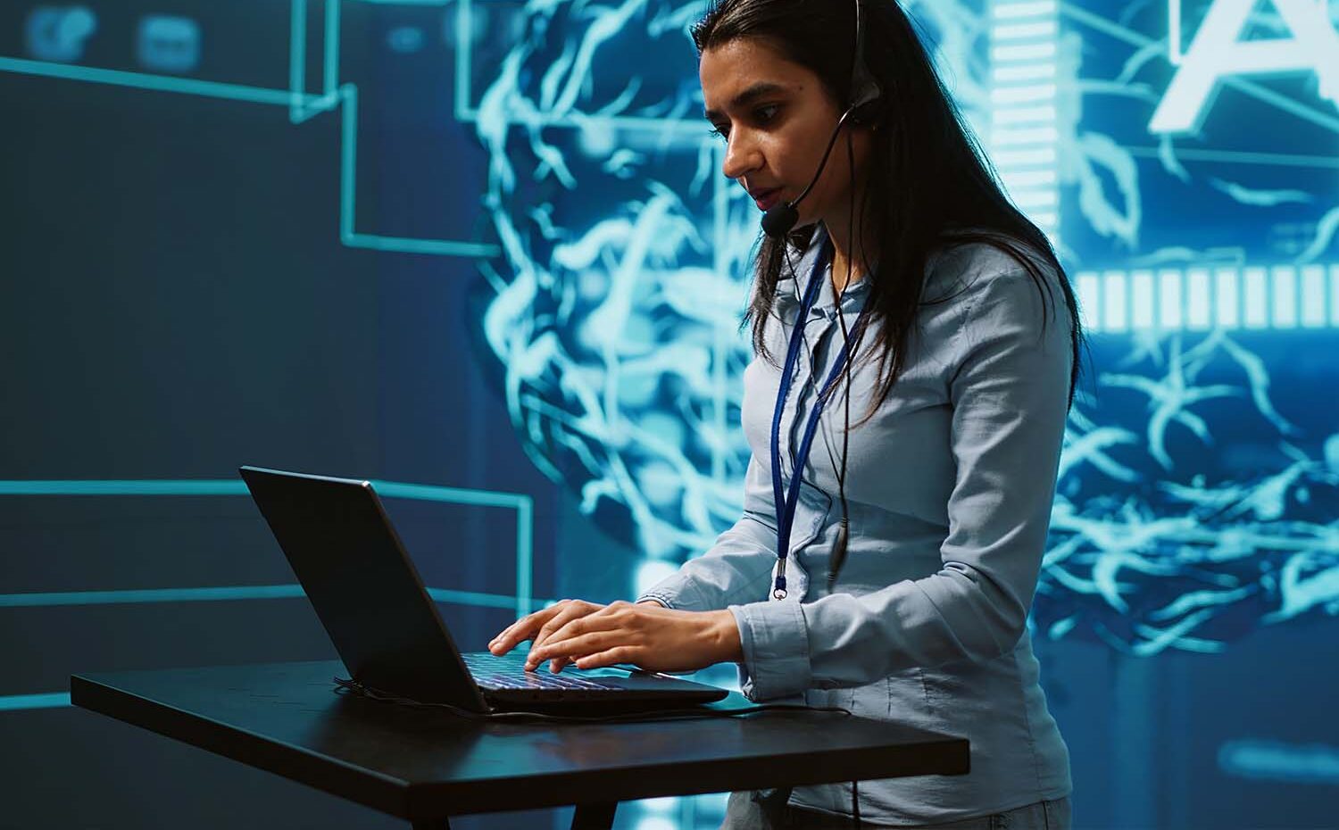 Recruiter wearing a headset and typing on a laptop in front of a glowing AI network graphic, symbolizing AI for recruiters at work