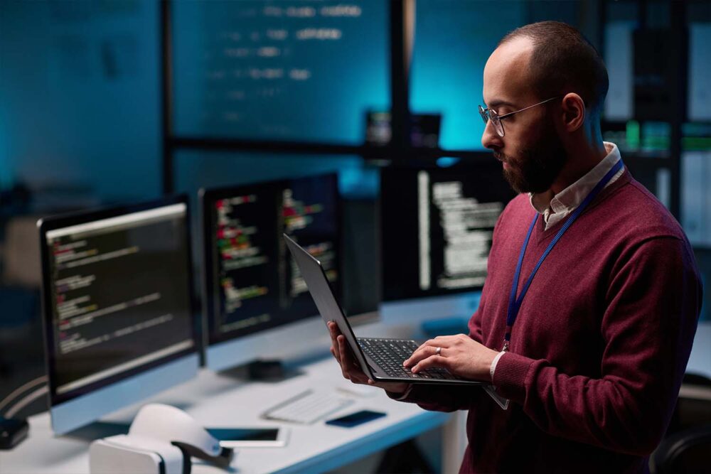 Finance leader reviewing financial data and code on multiple monitors, reflecting leadership trends toward digital finance oversight