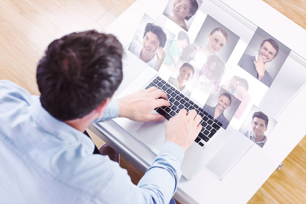 Recruiter using AI recruiting tools to browse floating candidate headshot photos while typing on a laptop for recruitment automation